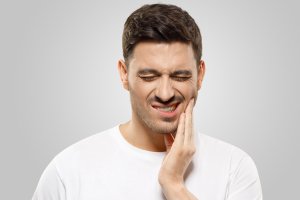 A man is experiencing pain before his jaw cyst removal procedure.